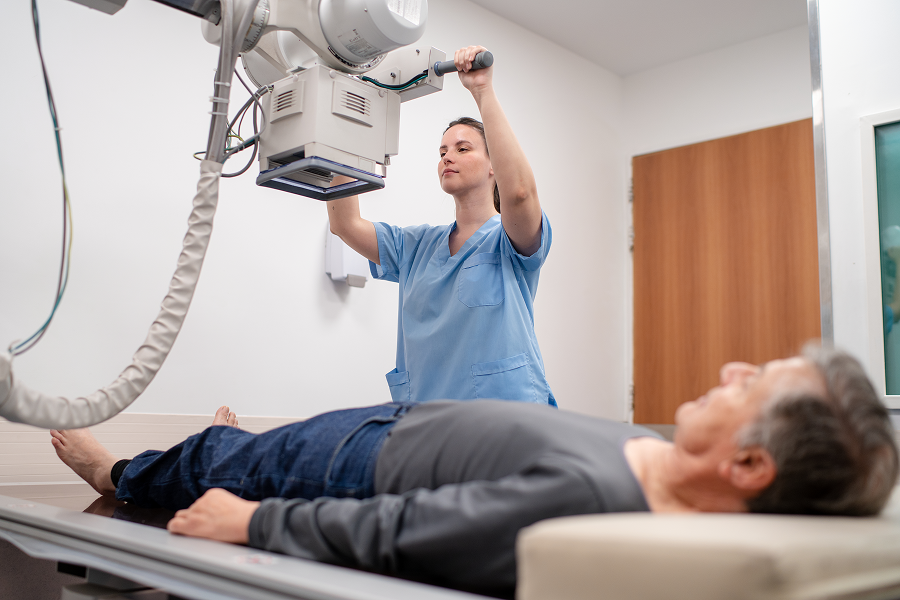 Radiographer preparing patient for X-ray