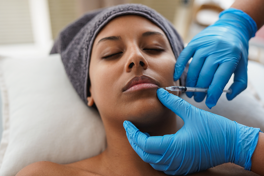 Facial injection procedure with blue gloves