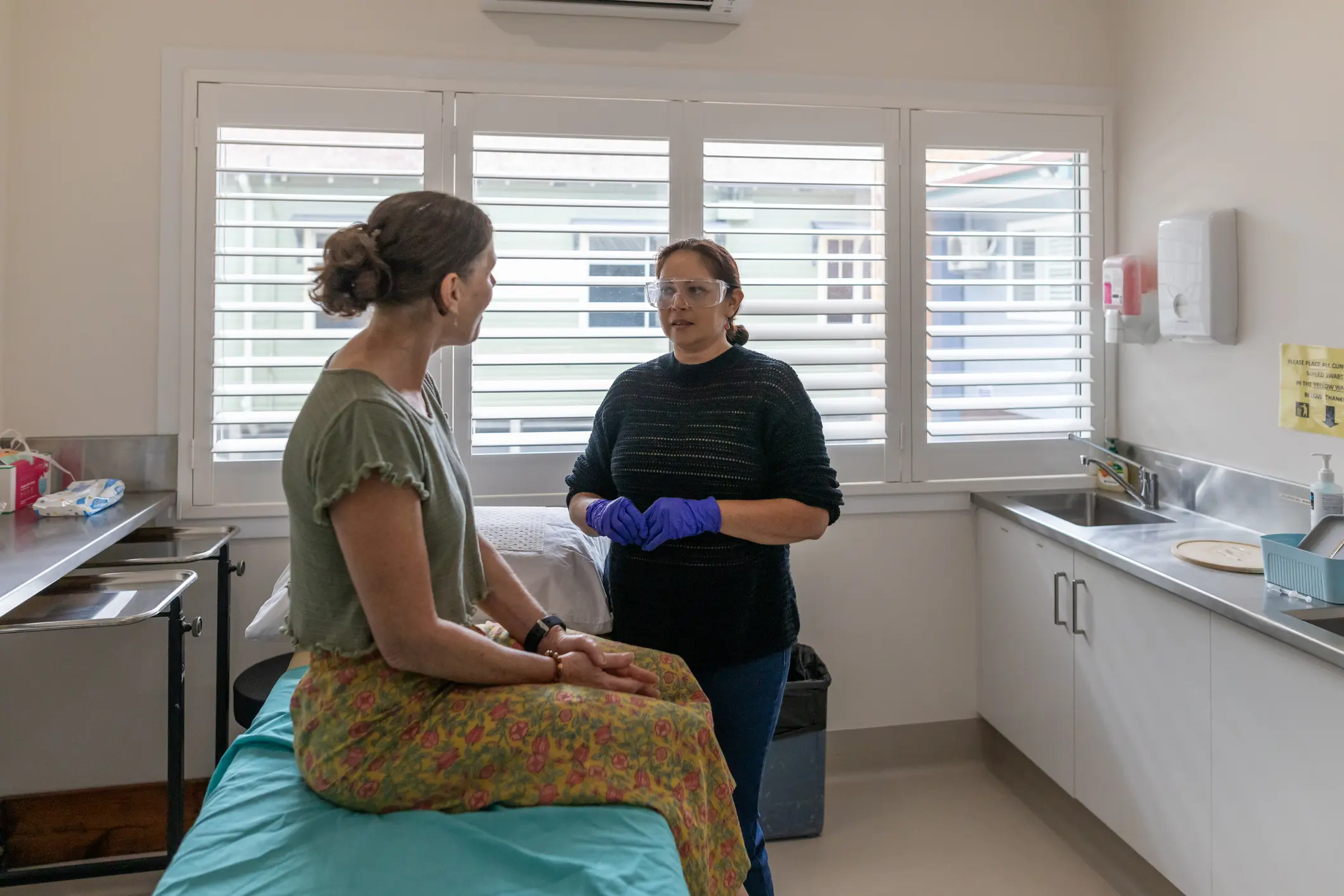 Woman receiving a vaccination injection from an Australian Aboriginal doctor in a modern medical clinic
