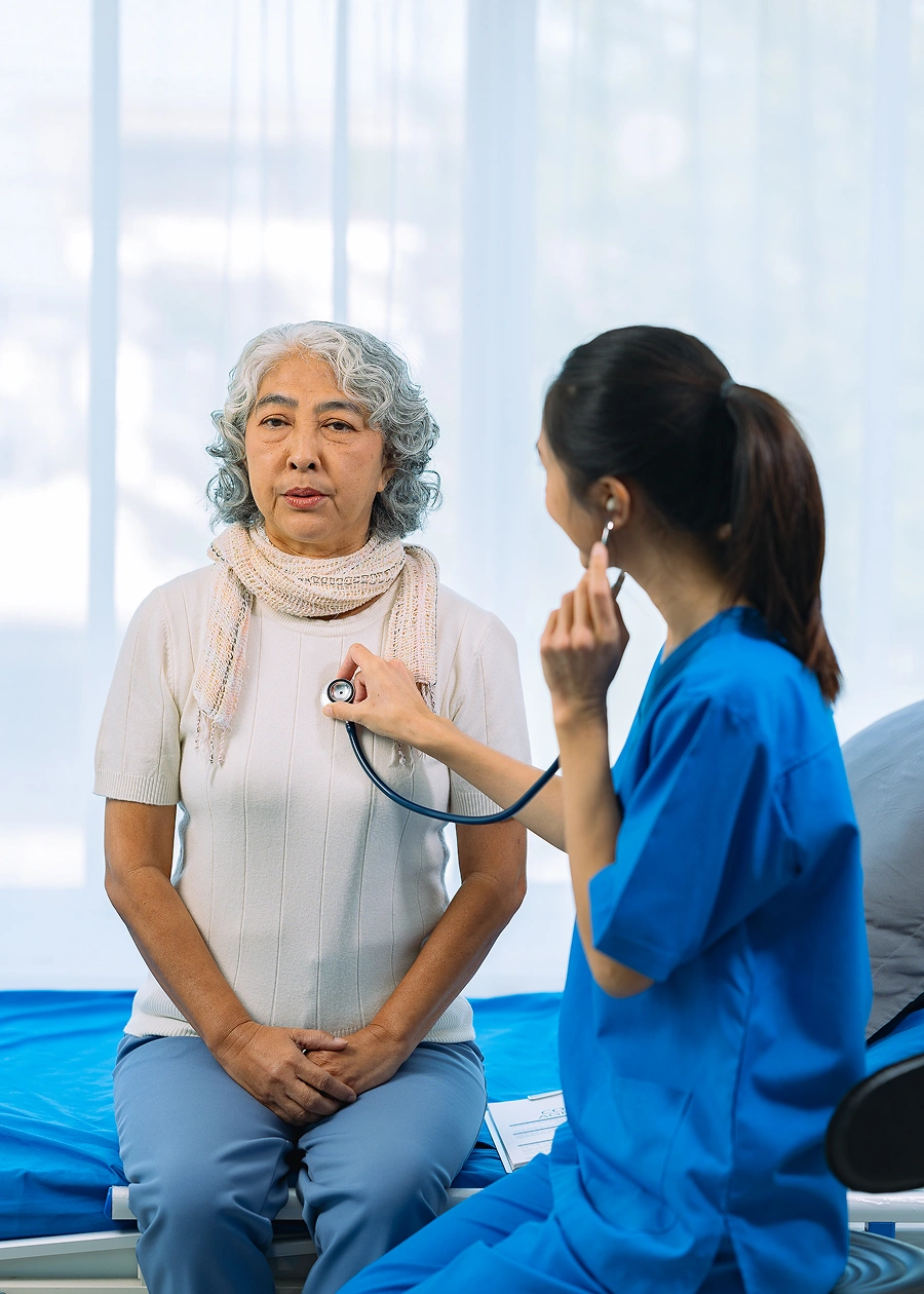 Nurse examining elderly woman in clinic