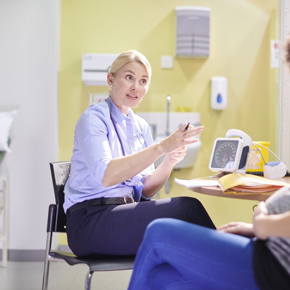 a doctor chats to a pregnant patient in her office